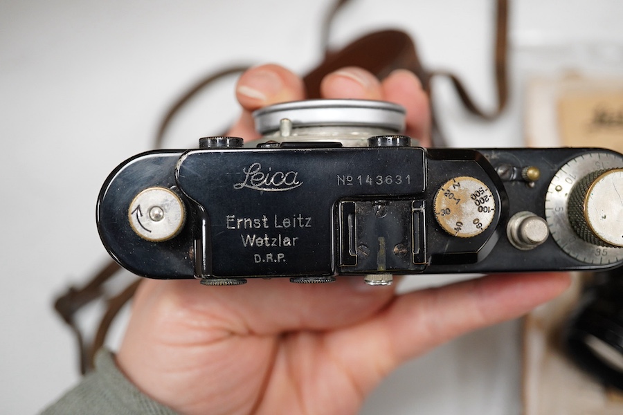 A Leica Model II camera in leather case, together with an Elmar 4.5/135mm lens, lens table booklet and instruction booklet. Condition - poor to fair.